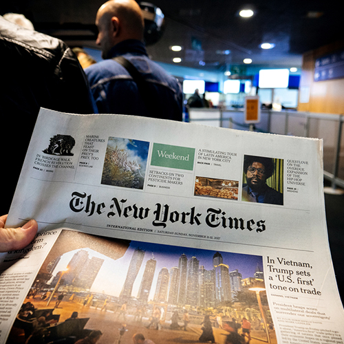 Person holding The New York Times.