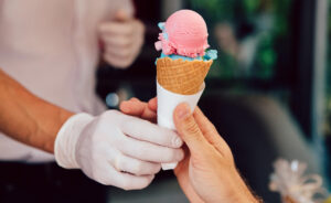 Person being handed an ice cream cone.