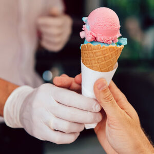 Person being handed an ice cream cone.