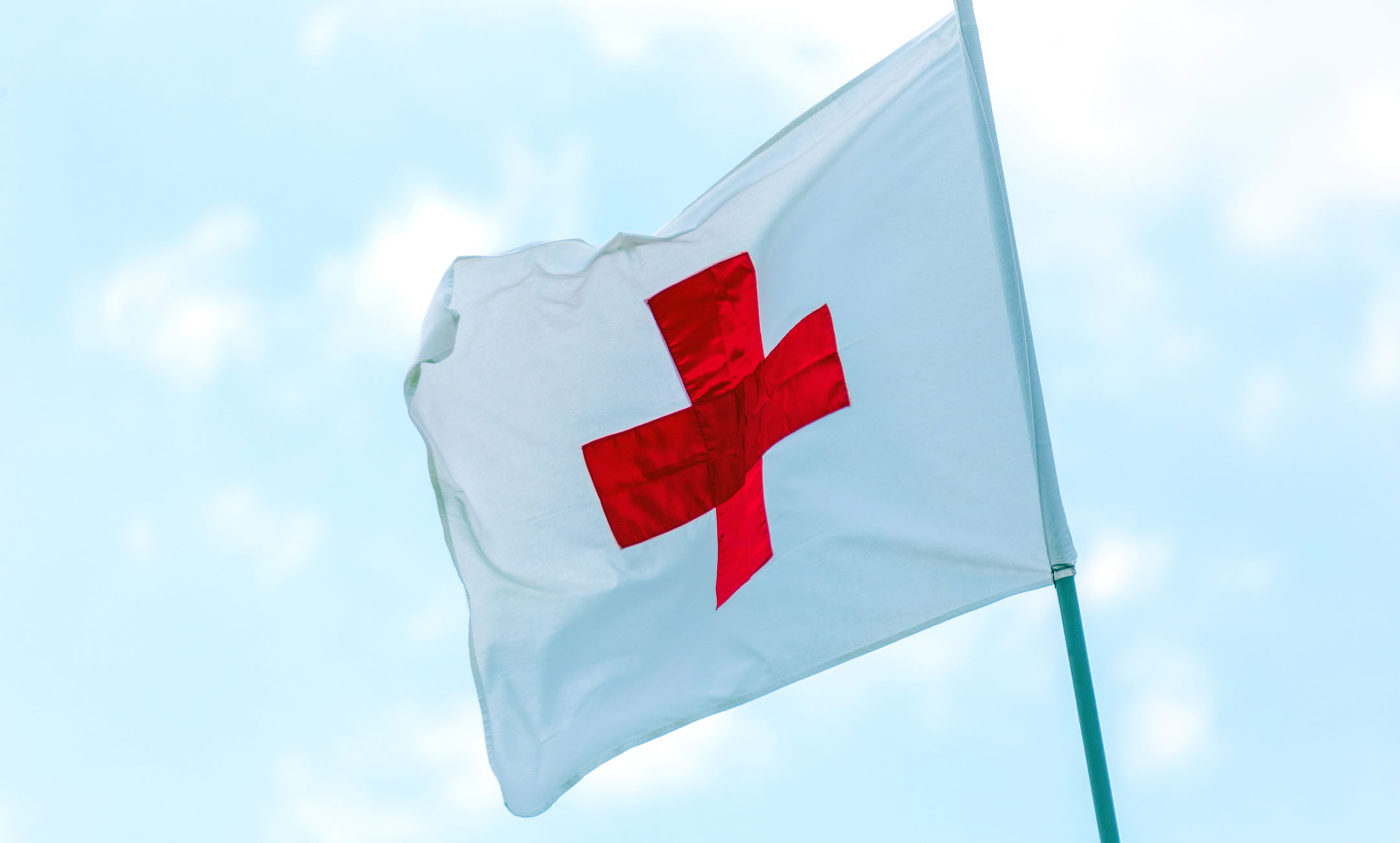 Red Cross flag waving in the wind.