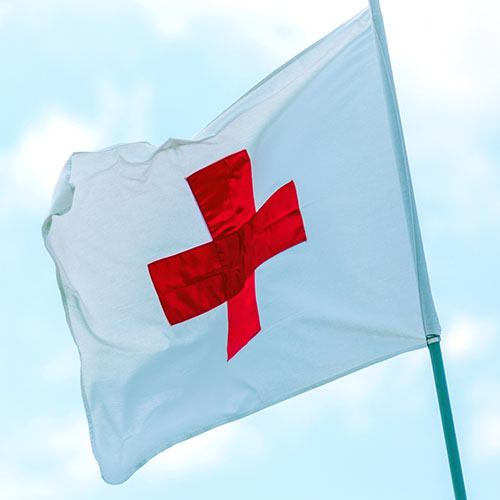 Red Cross flag waving in the wind.