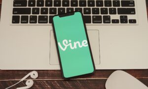 A phone show the logo for Vine on top of a computer.