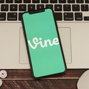 A phone show the logo for Vine on top of a computer.