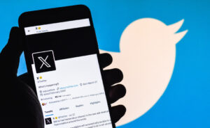 X app with Twitter bird in background