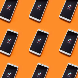 Phones showing TikTok app on orange background