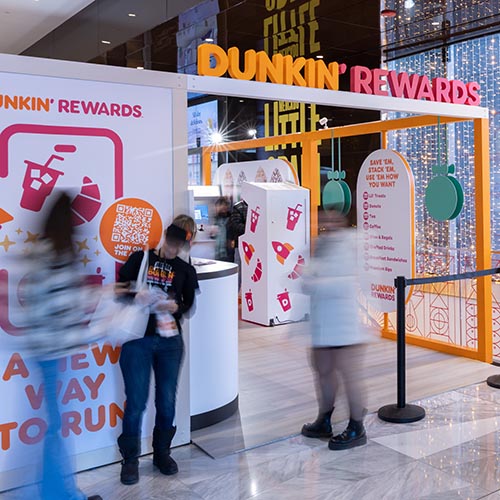 Entryway to Dunkin' Rewards Pop-Up Lounge activation bustling with visitors