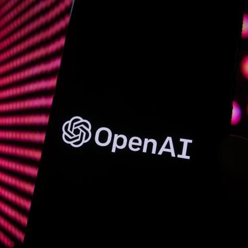 OpenAI logo on a black phone screen with pink in the background behind the phone