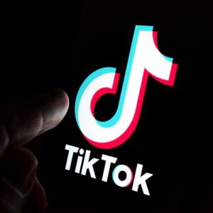 Finger on a phone screen with the TikTok app on it