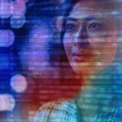 A woman looking at a screen of computer code.